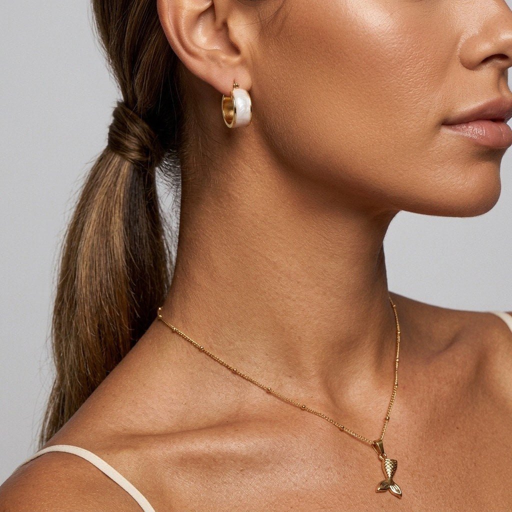 gold mermaid charm necklace with a textured tail pendant and delicate chain