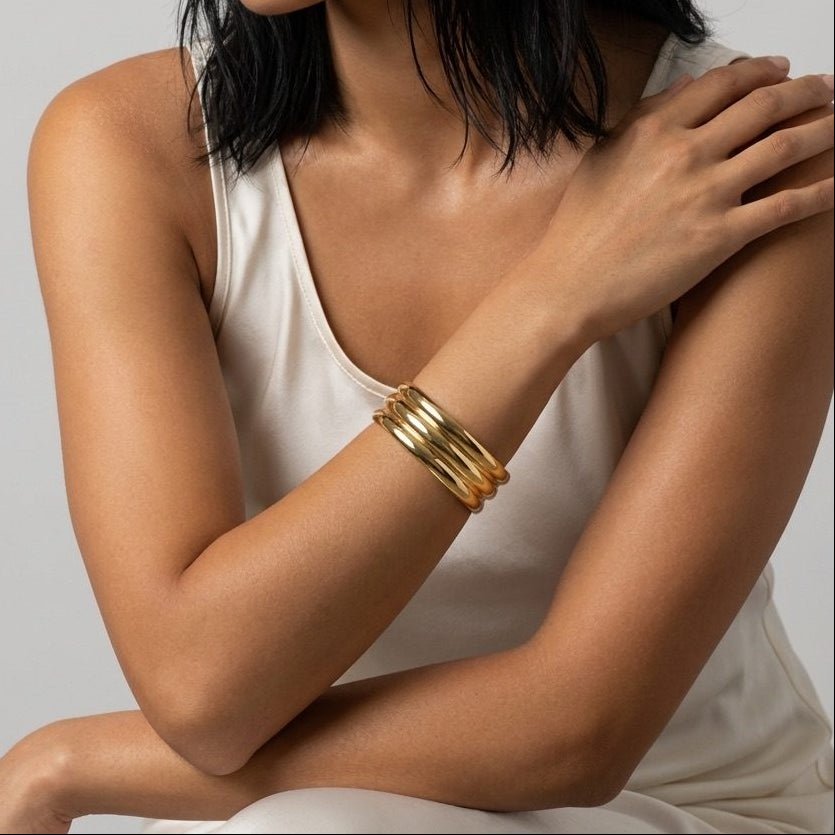 gold multi band cuff bracelet with connected polished bands forming a bold sculptural design
