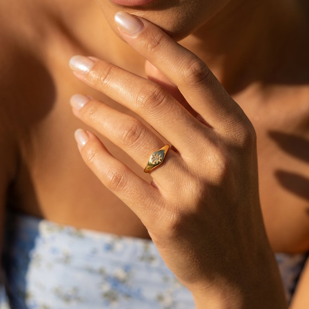 gold starburst signet ring featuring a raised diamond shaped face with a sparkling star detail and smooth gold band for timeless women's jewelry