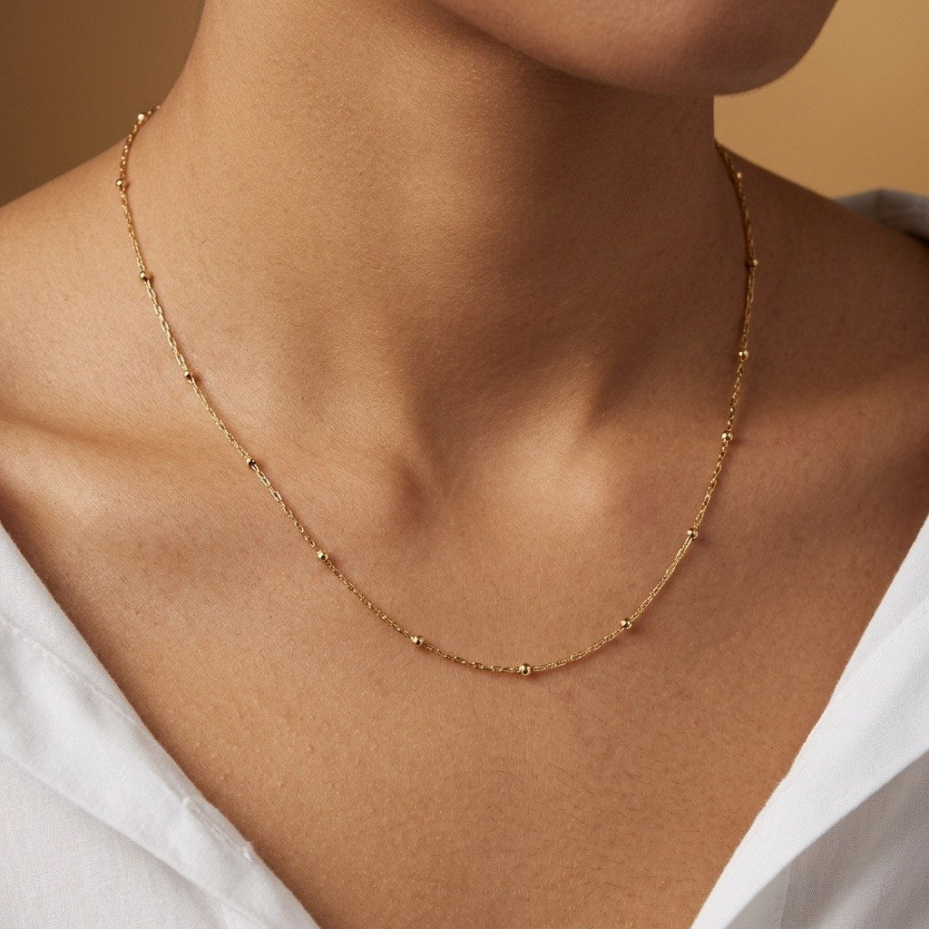 gold station chain necklace featuring subtle bead details on a fine lightweight chain