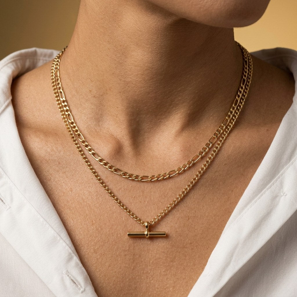 gold t-bar layered necklace with mixed chain textures and a sleek horizontal bar pendant