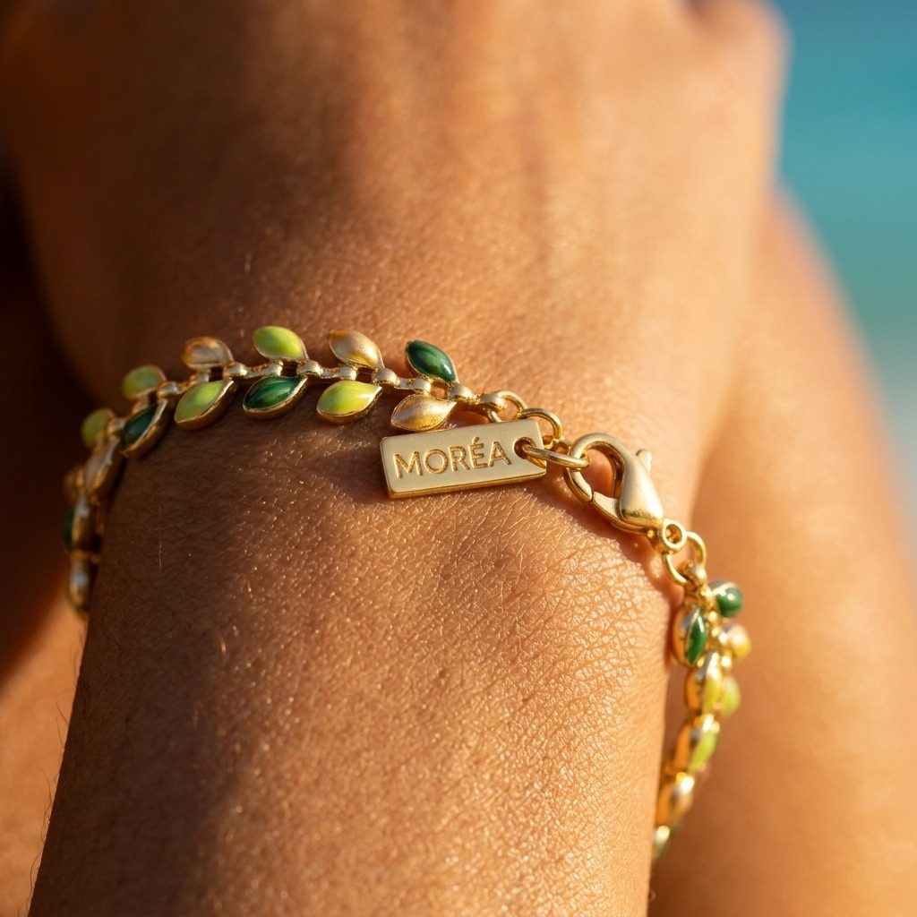 green leaf gold bracelet featuring delicate green leaf details on a gold-tone chain worn at the beach