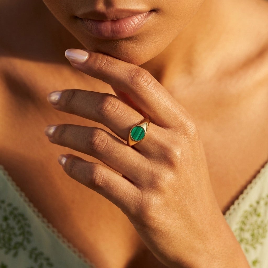 green stone signet ring with round gemstone in a gold setting
