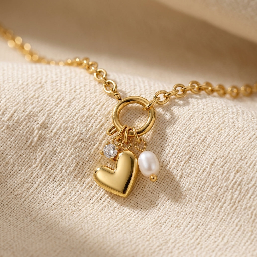heart pearl drop necklace for women featuring a shiny gold heart charm and delicate white pearl pendant on a textured gold chain