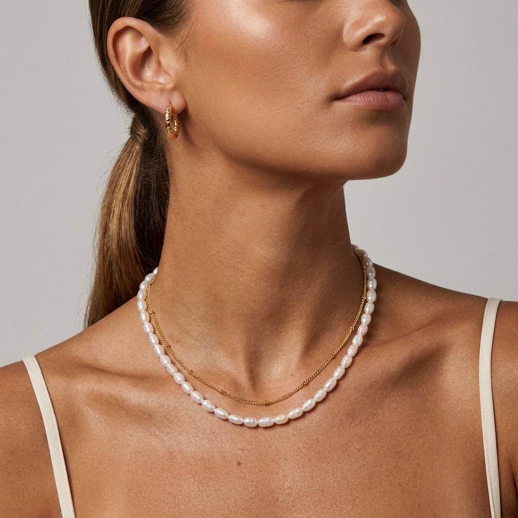 delicate gold necklace layered with a strand of freshwater pearls