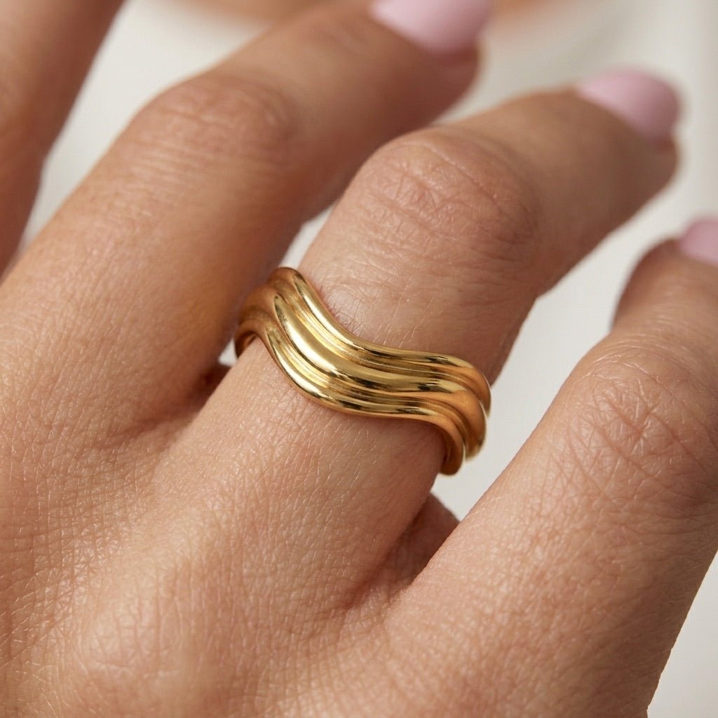 layered gold ring with multiple flowing bands and a sculptural polished design