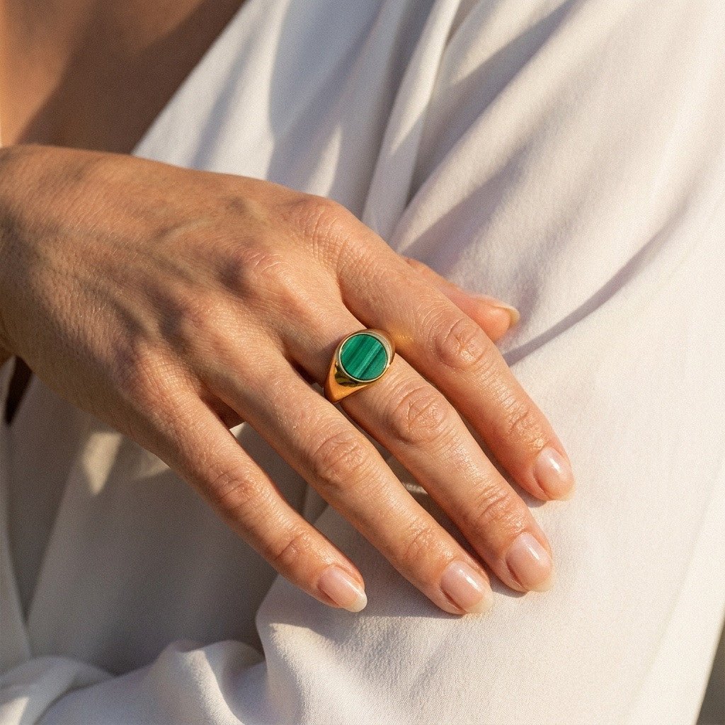 malachite gold ring with round green stone set in a polished gold band