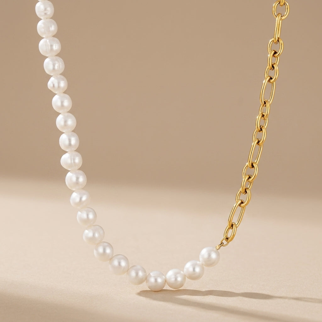 modern gold pearl necklace featuring a half pearl half chain design styled on a model with gold heart drop earrings