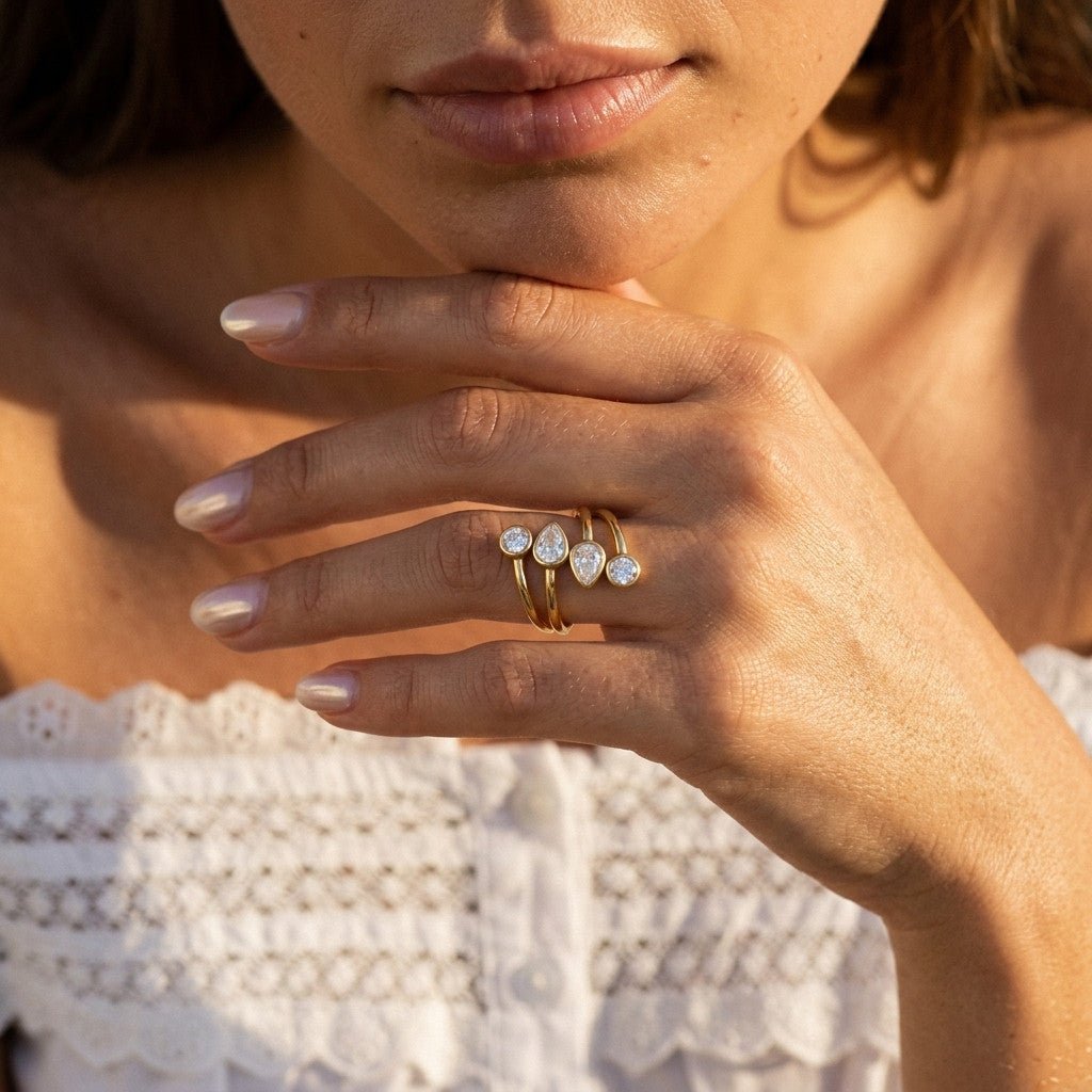 multi gem gold ring with mixed shaped clear stones set across a polished layered band