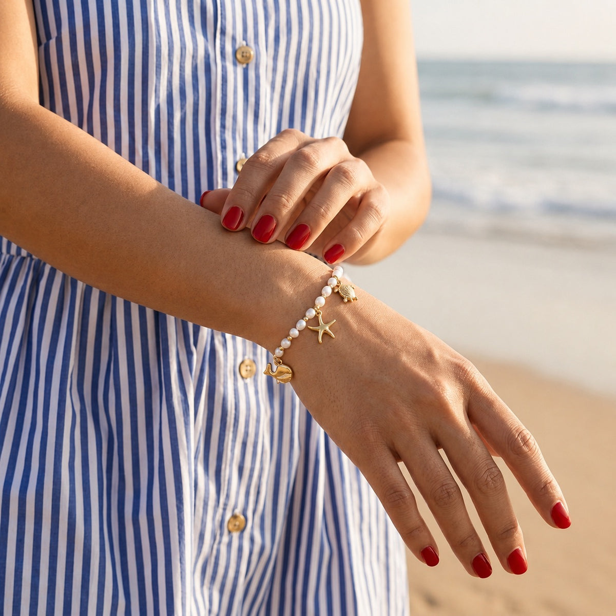 nautical gold pearl bracelet featuring small white freshwater pearls, polished gold beads and charming ocean inspired pendants