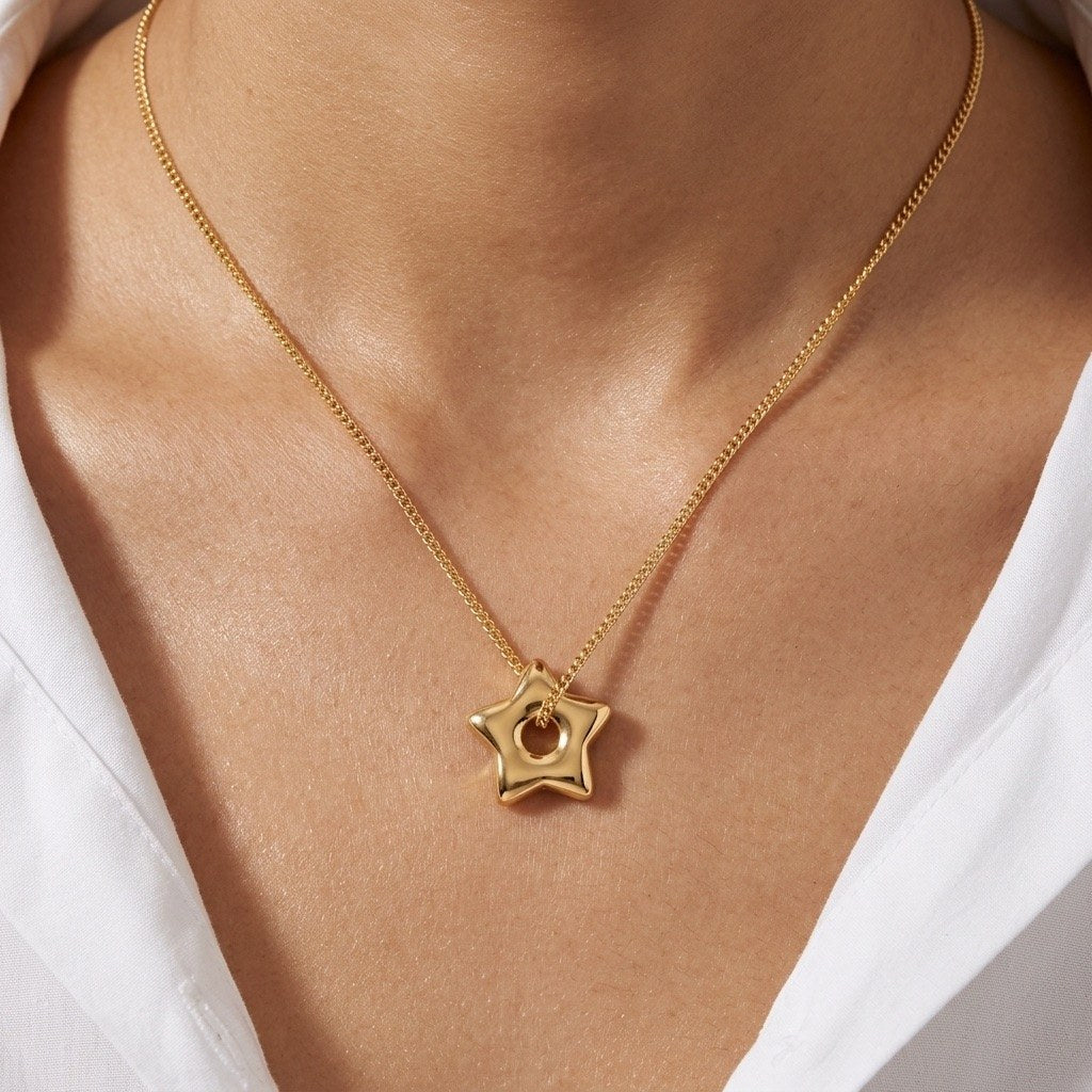 open star pendant necklace with a smooth polished gold finish on a delicate chain