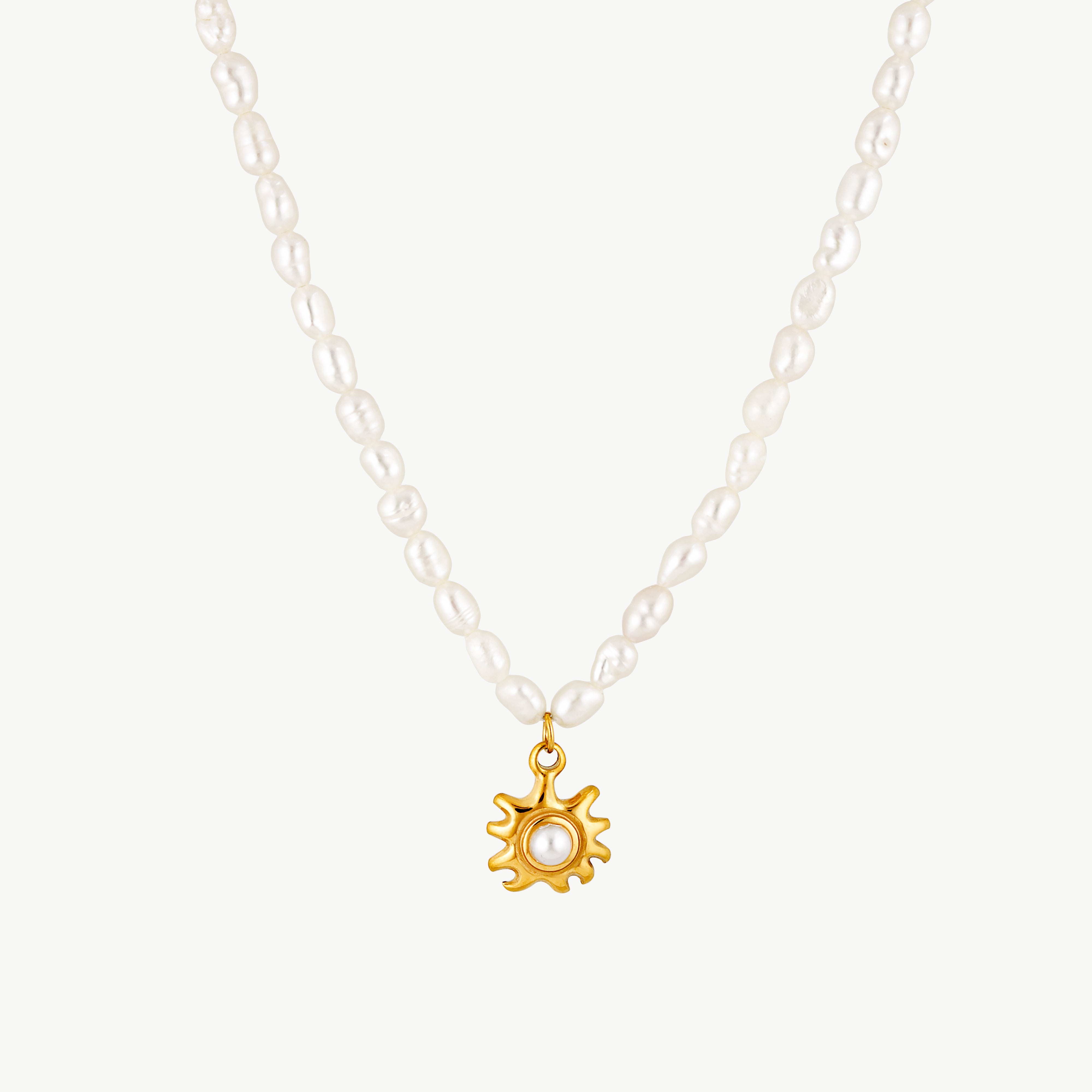pearl and sun necklace with luminous white pearls and sculptural gold sun pendant featuring a delicate pearl center