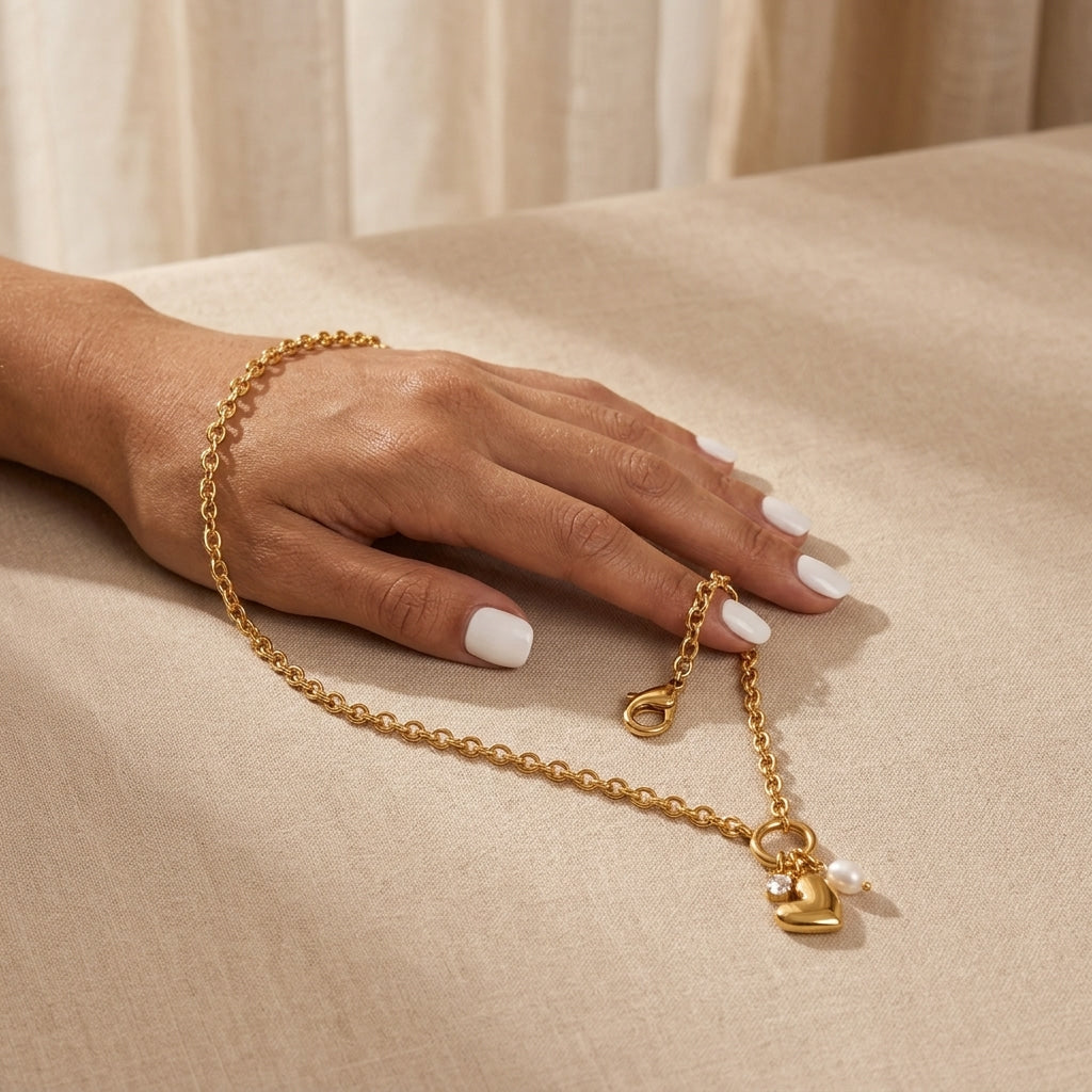 pearl heart pendant necklace for women featuring a gold heart charm and luminous white pearl suspended from a circular gold ring