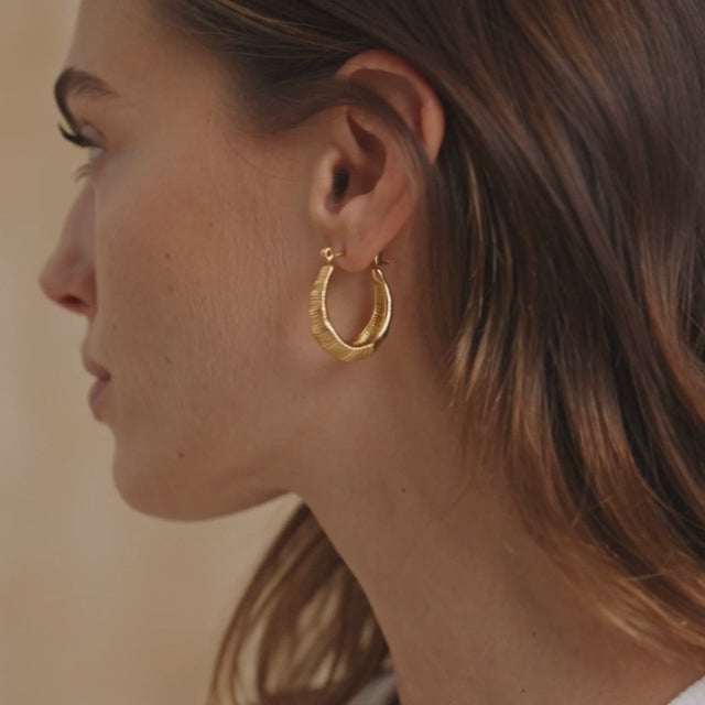 ribbed gold dome earrings for women featuring a bold curved hoop design with fine engraved lines and a shiny gold finish for elegant everyday styling