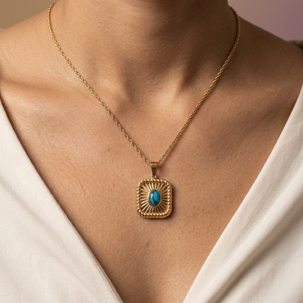rectangular turquoise gold necklace with a textured frame and bright blue center stone