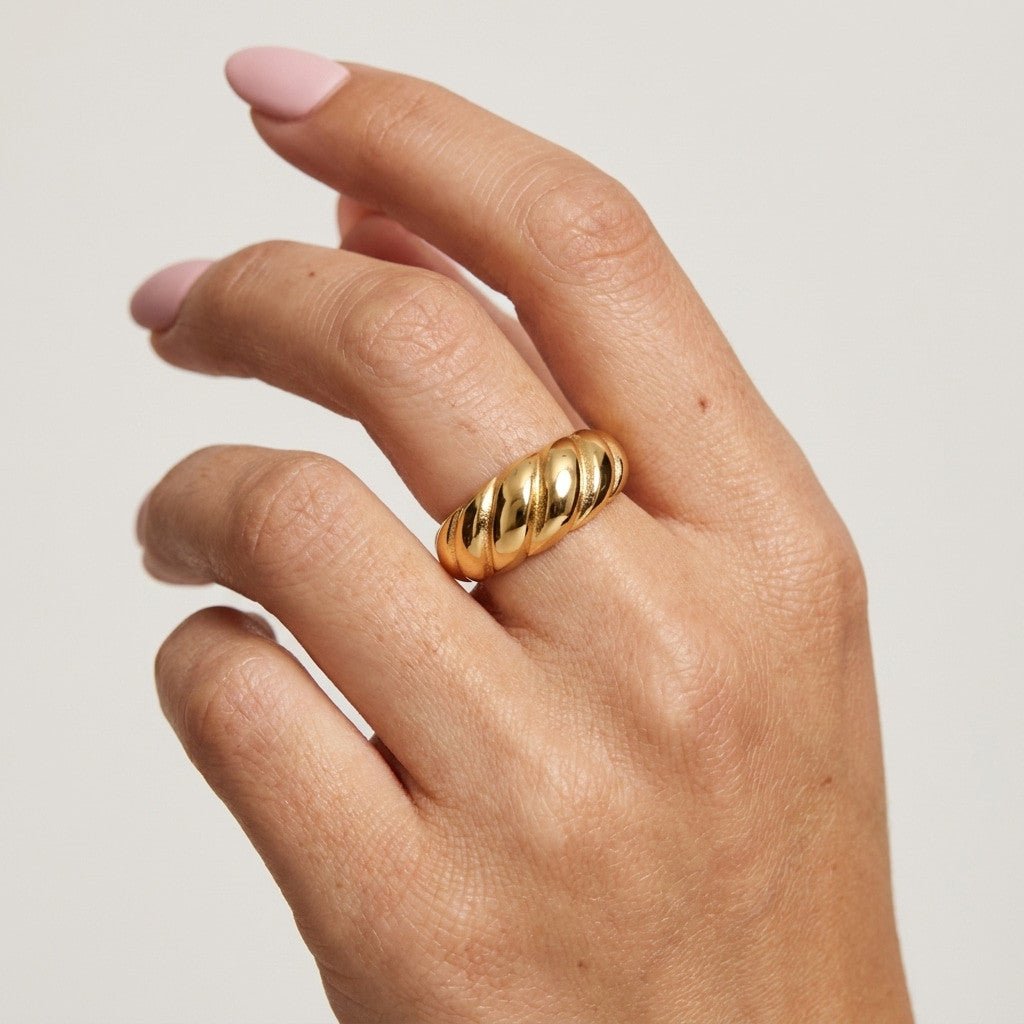 ribbed gold ring with a bold rounded band and polished textured finish