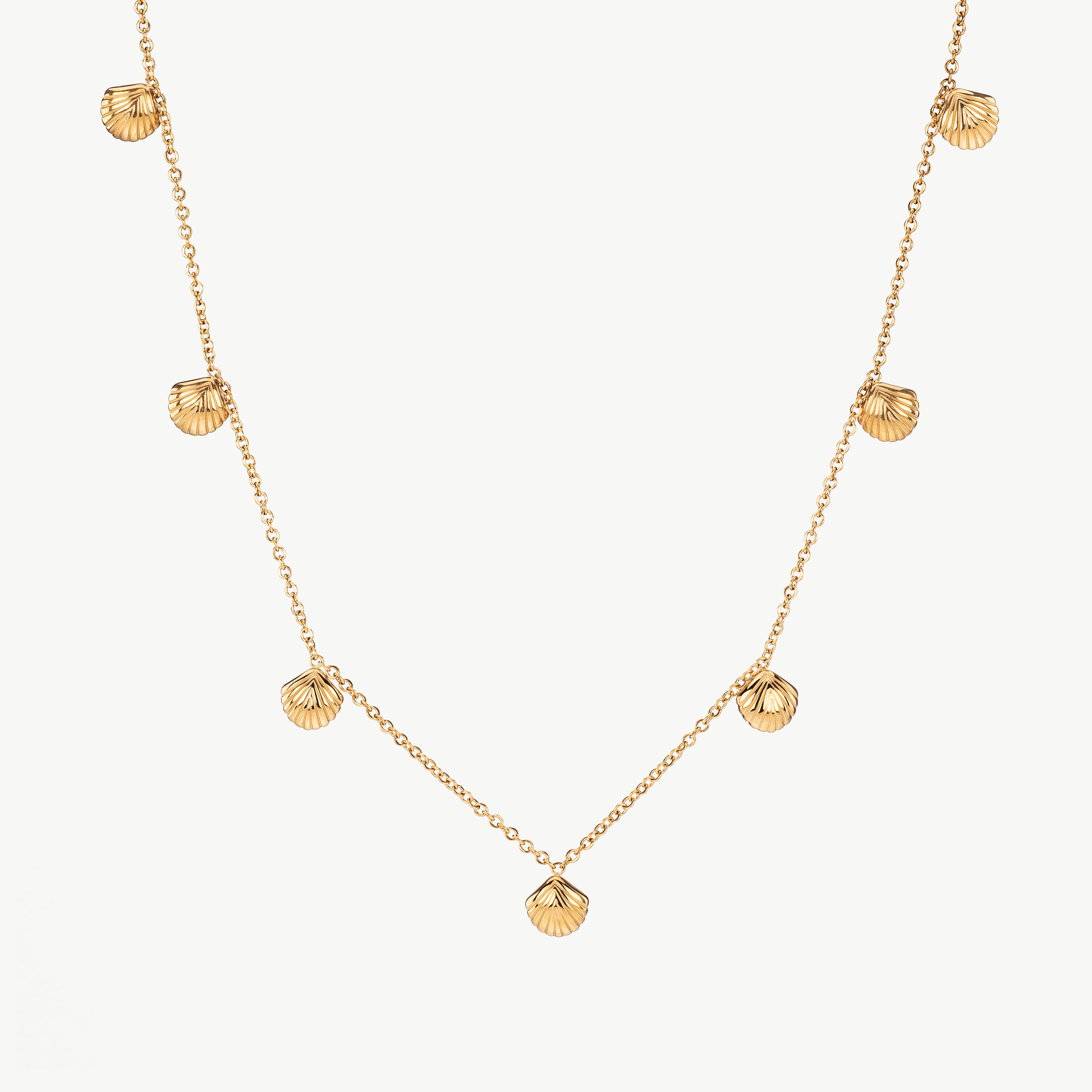 seashell charm necklace in gold with small shell pendant, gold seashell charm necklace with polished finish and ocean theme necklaces inspired detail