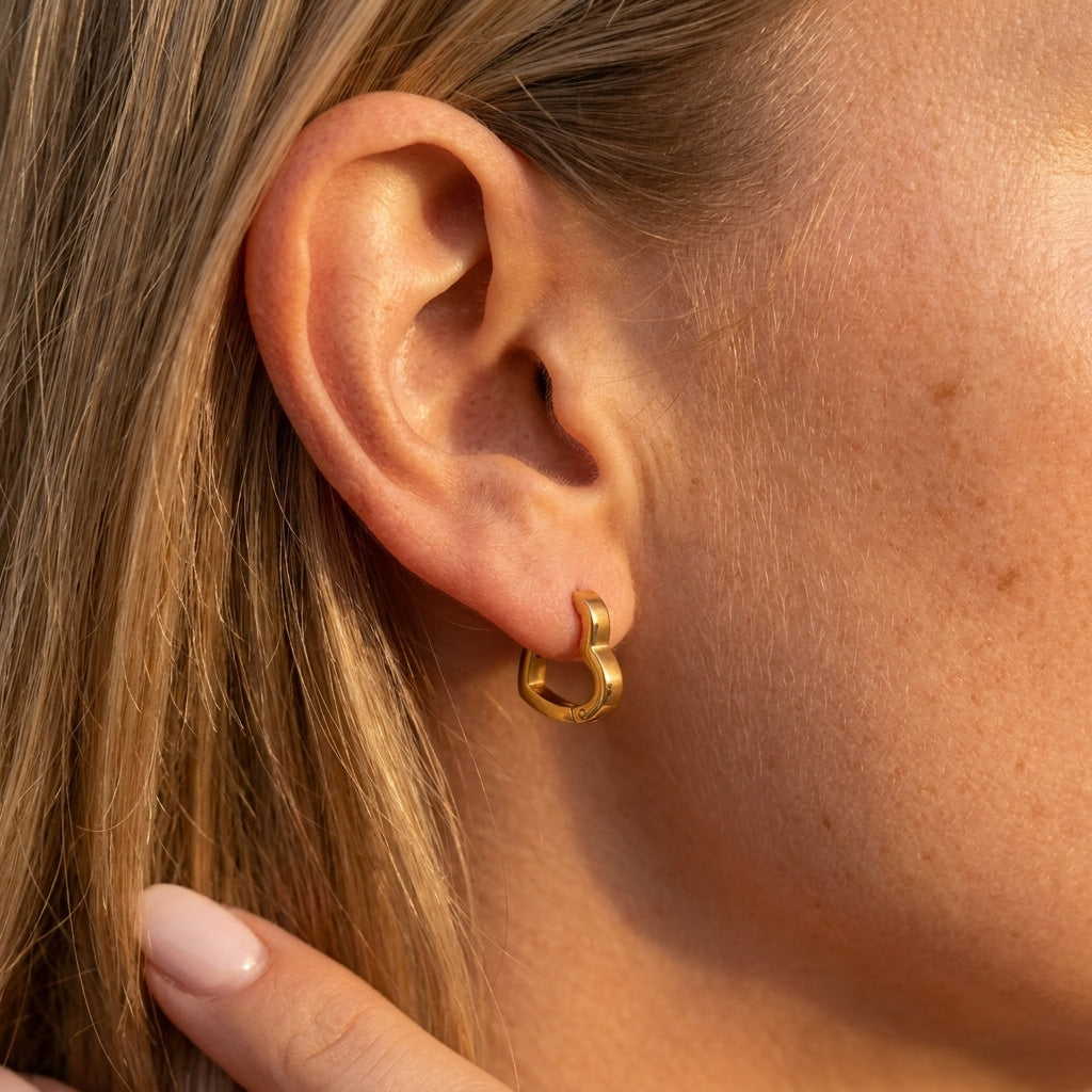 small gold heart hoop earrings with a polished heart shaped design