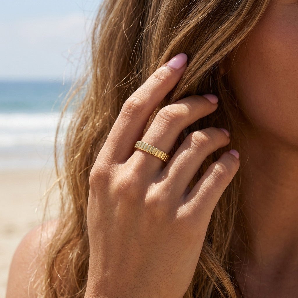 stacking band ring with structured ridged details and a polished gold finish