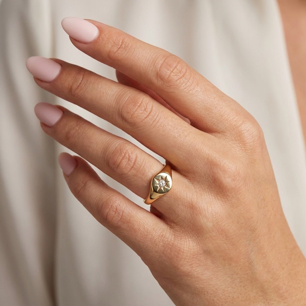 starburst signet ring with a sparkling center stone and polished gold setting