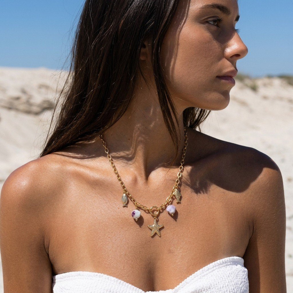 starfish charm necklace with ocean-inspired fish and seashell charms on a gold chain