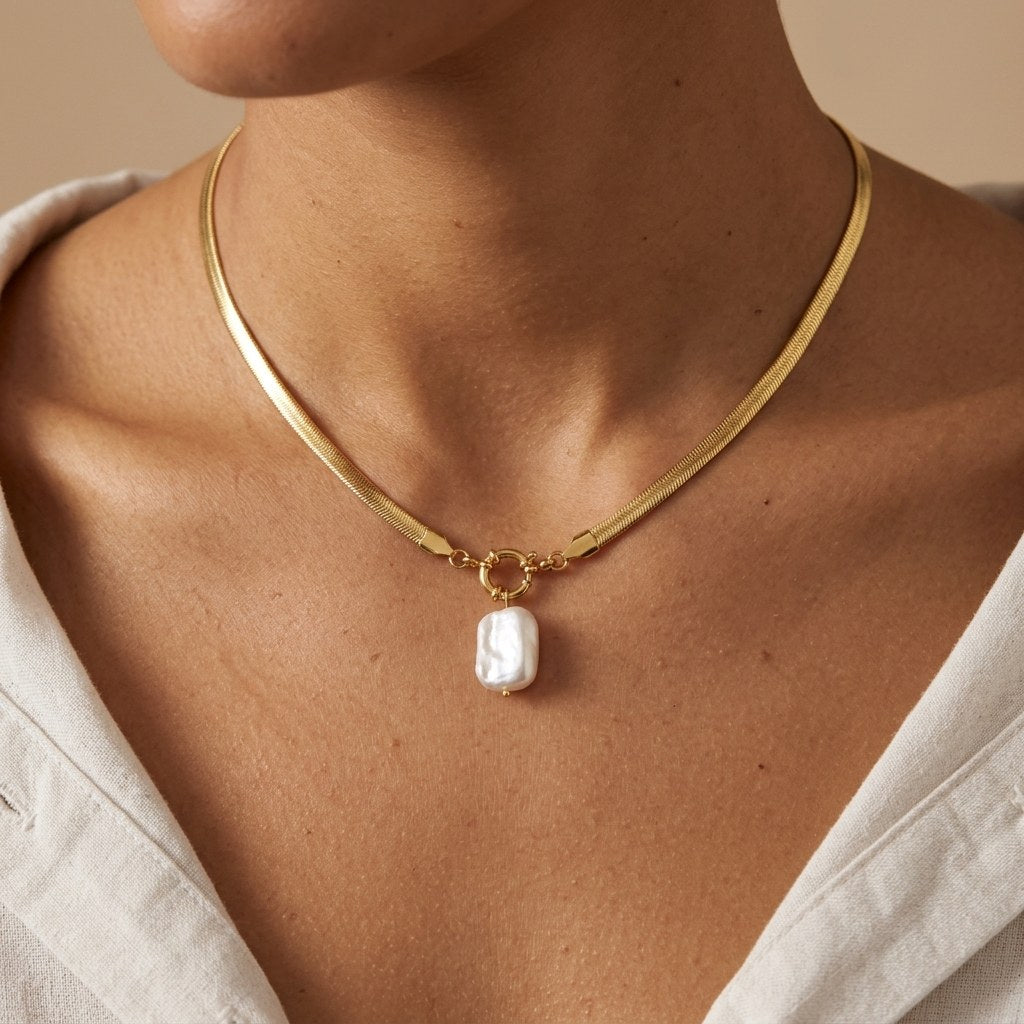statement pearl choker necklace featuring a white pearl pendant with a bold polished gold-tone chain