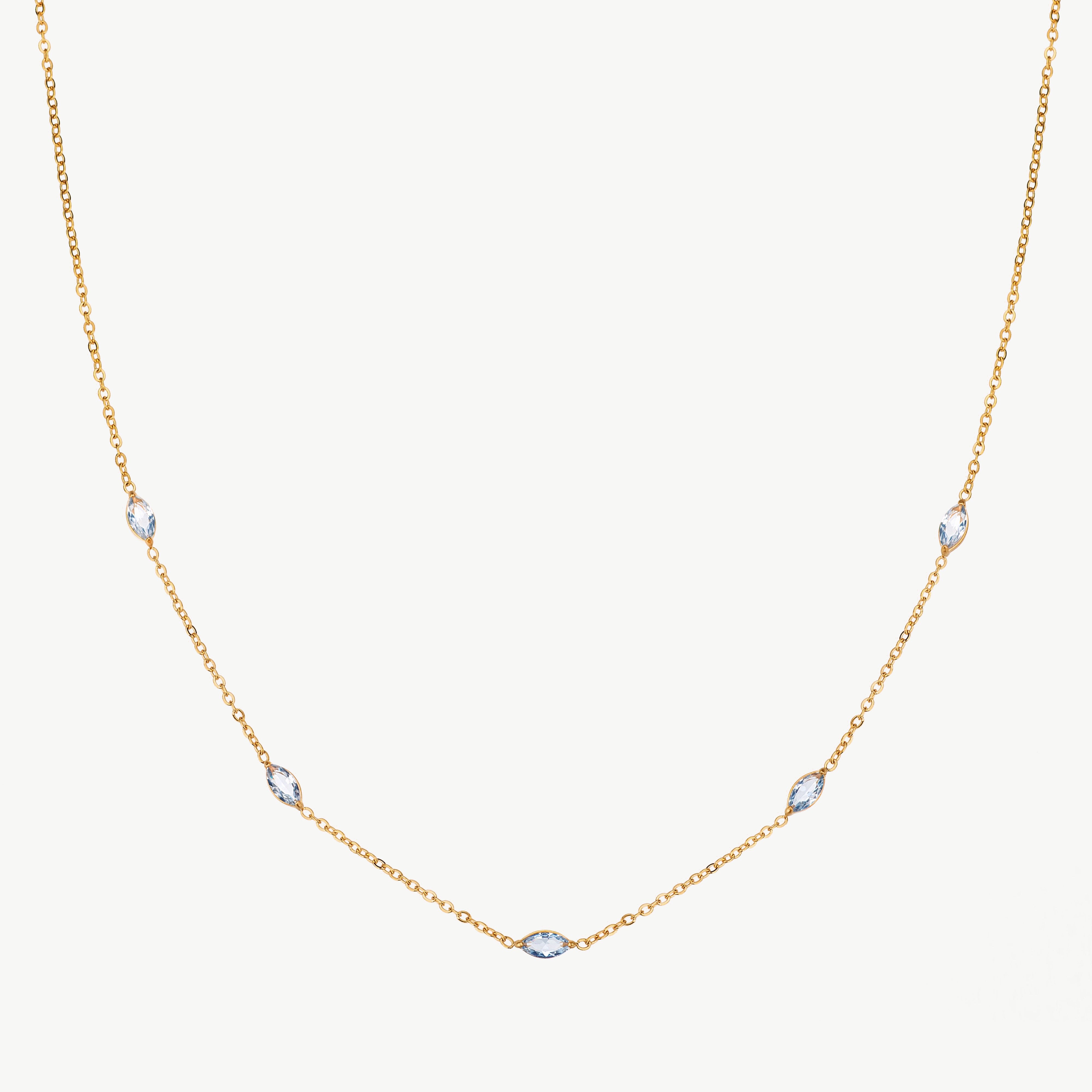station necklace in gold with spaced crystal details, minimalist gemstone necklace with fine chain and subtle light reflective accents