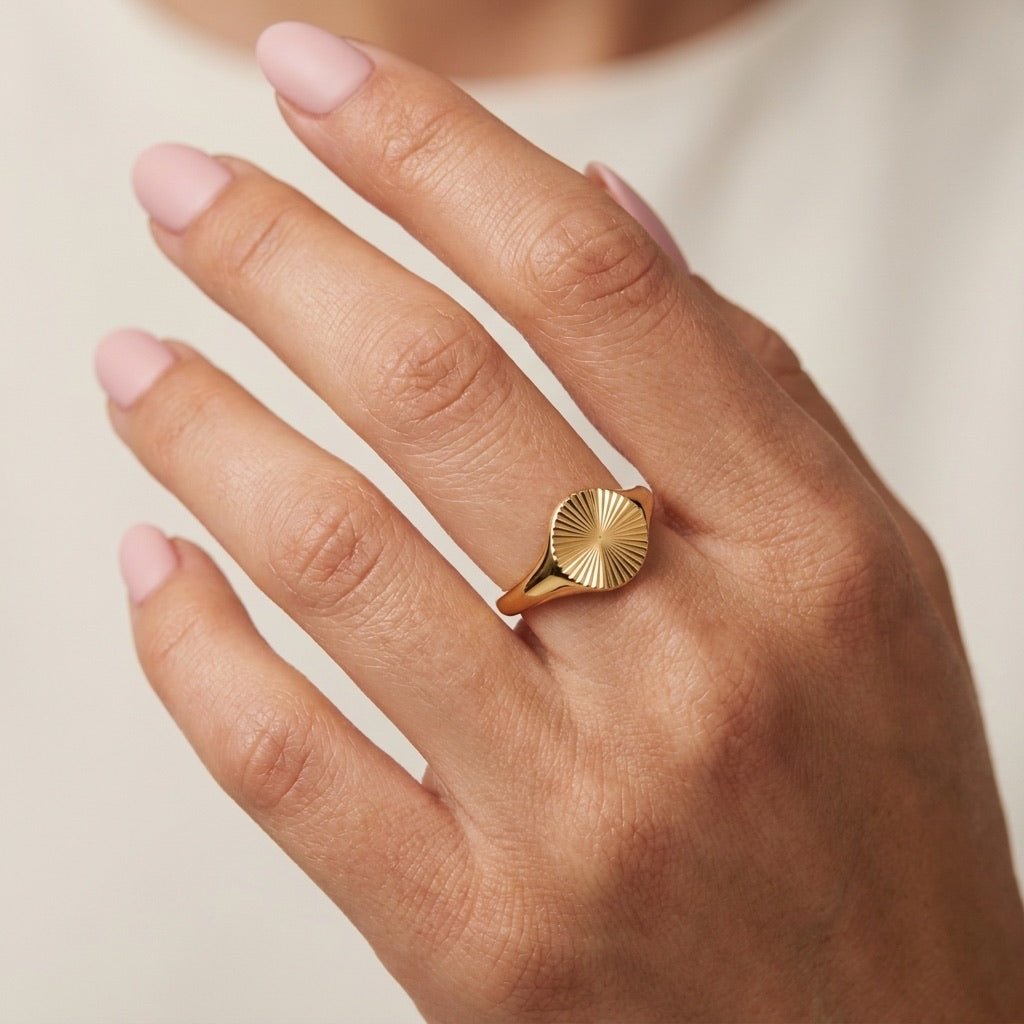 sunburst ring with a round engraved design in polished gold