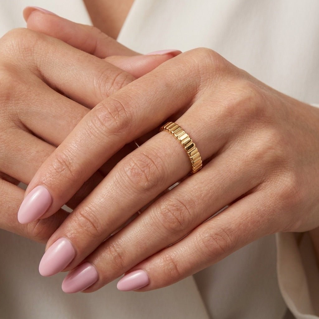 stackable gold band with ribbed detailing and a slim polished finish, worn on hand