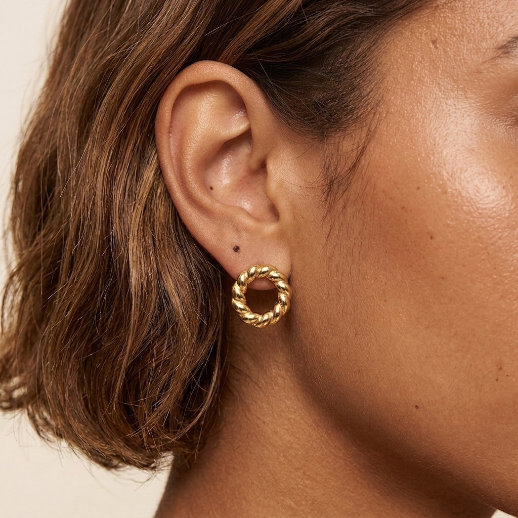 twisted gold hoop earrings for women featuring an elegant rope inspired design with a shiny gold finish styled on a model