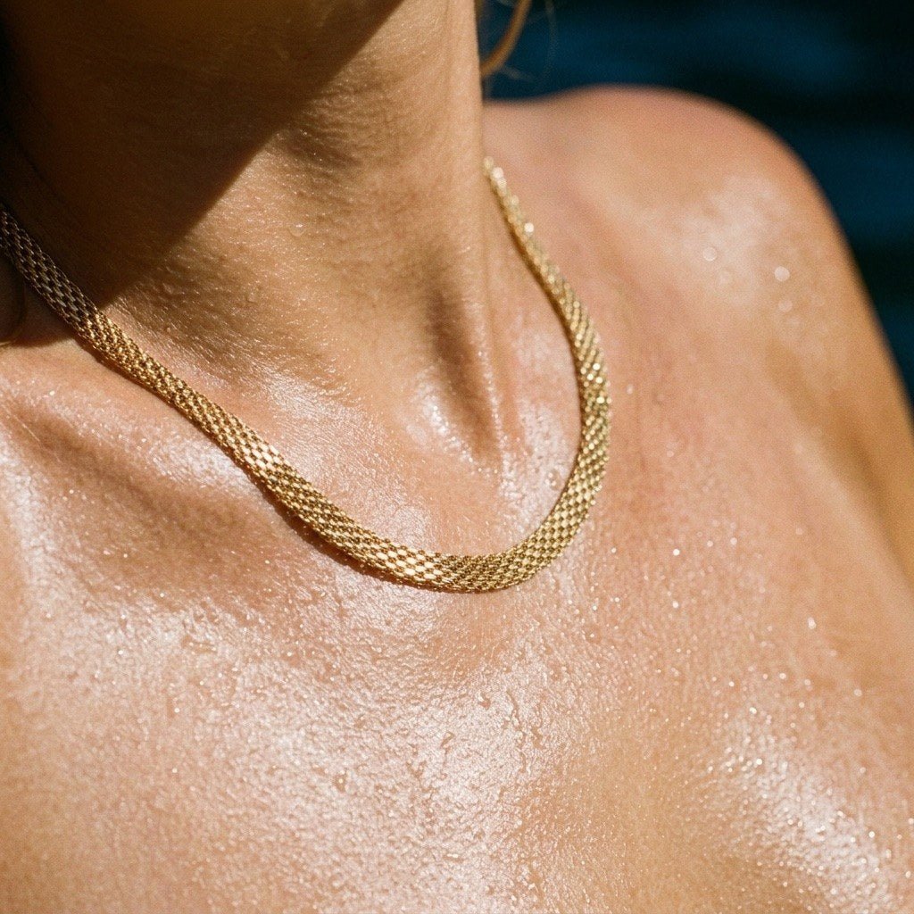 wide gold mesh chain necklace with a dense woven texture creating a sophisticated statement style